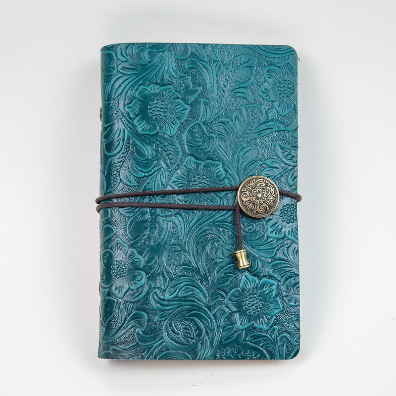 Blue travel journal with a textured cover, wraparound cord and decorative charm.